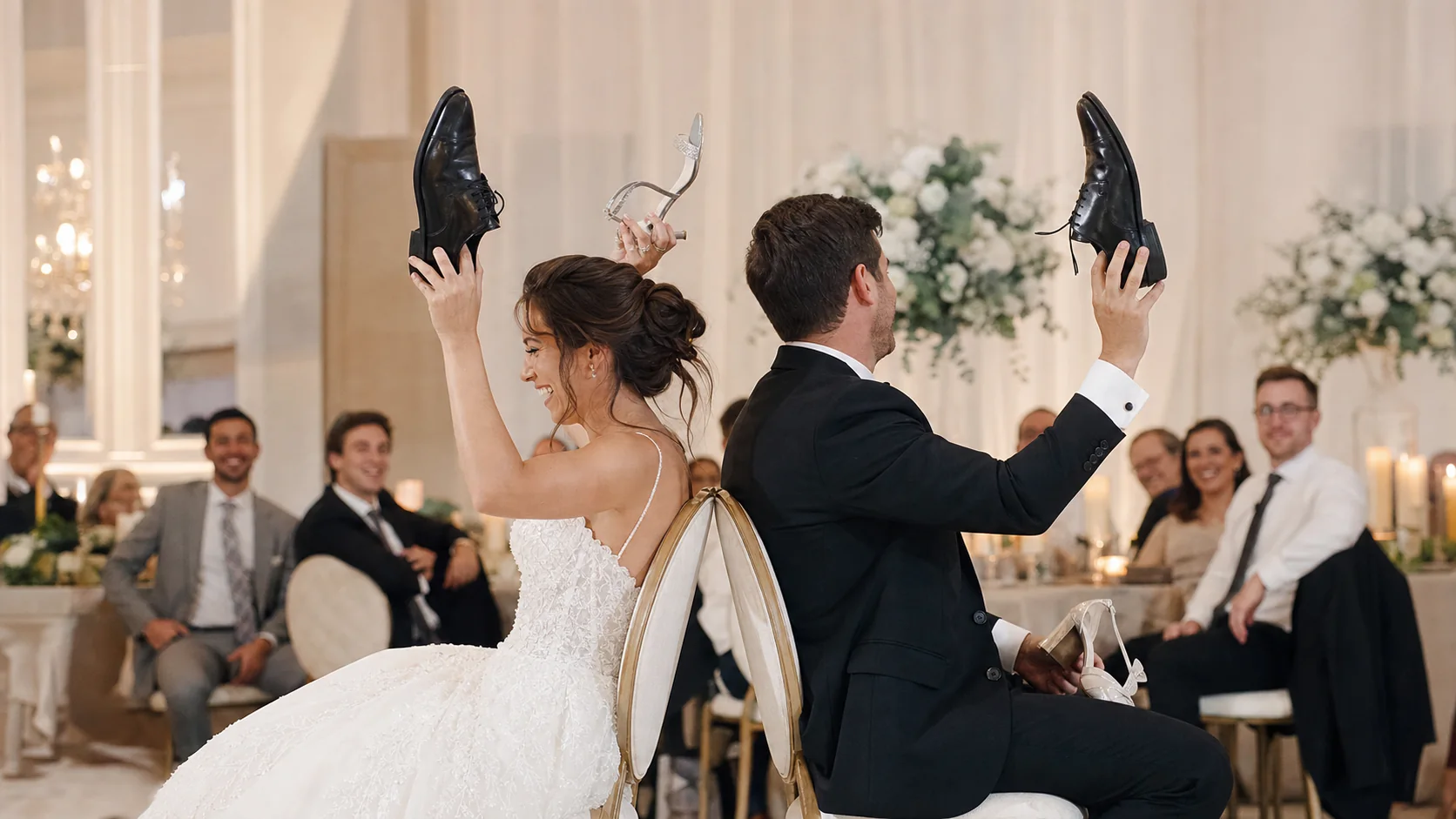 A newly married couple laughing while playing the wedding shoe game